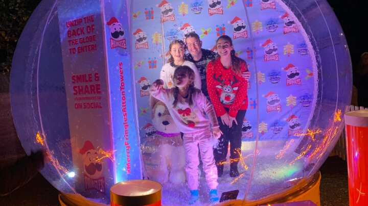 family inside giant snow globe photo booth