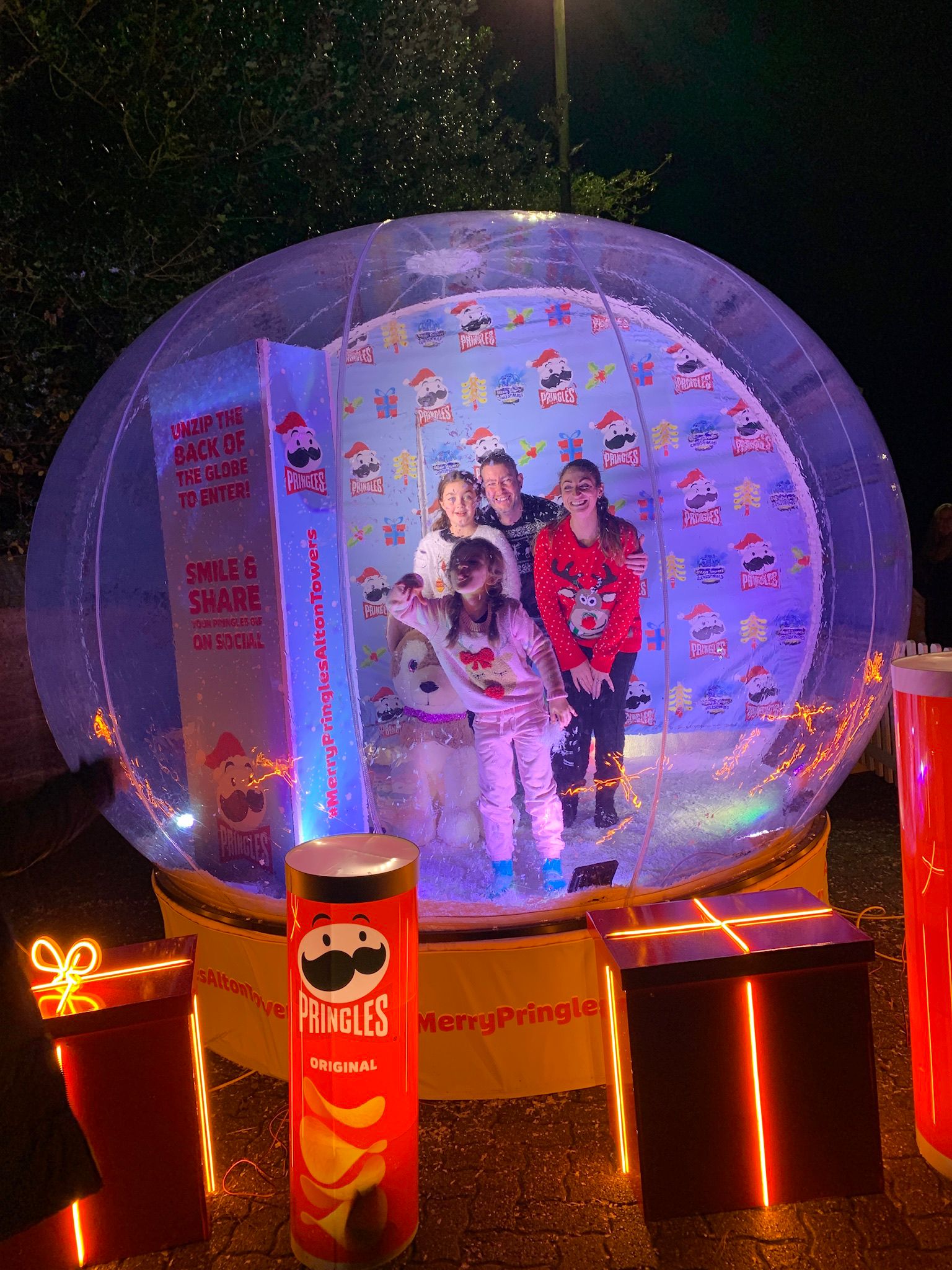 family inside giant snow globe photo booth